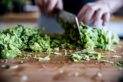 Cropped image of person cutting vegetable in kitchen at home