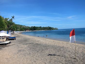 Scenic view of beach against blue sky