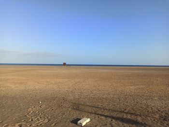 Scenic view of beach against clear blue sky