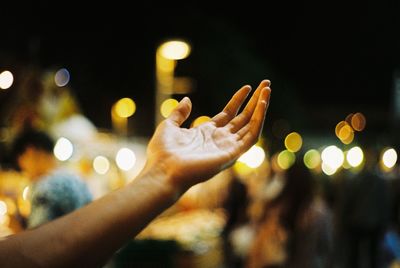 Close-up of woman hand with illuminated lights at night