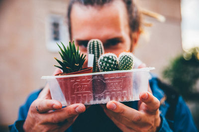 Midsection of man holding pine cone