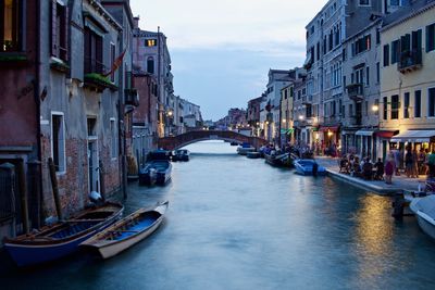 Canal amidst buildings against sky in city