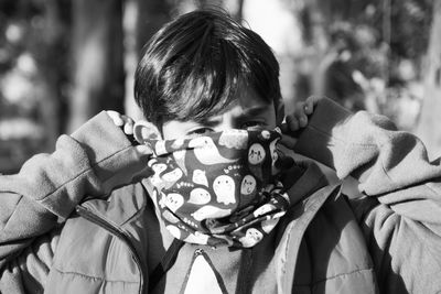 Portrait of boy covering his face with protective mask