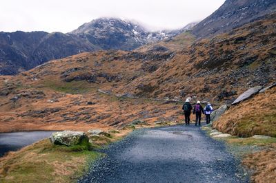Rear view of people hiking through mountains of snowdonia, wales