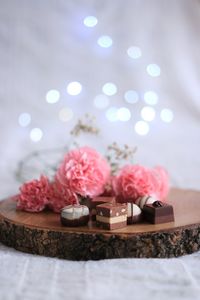Close-up of chocolates and flowers on cutting board