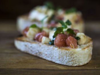 Close-up of bruschetta served with tomatoes on cutting board