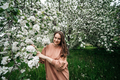 Beautiful young girl in the garden of blooming apple trees