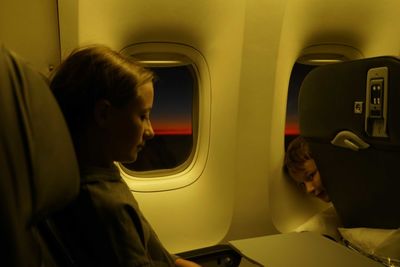 Side view of woman sitting in airplane