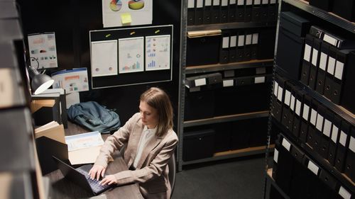 Side view of young woman standing in factory