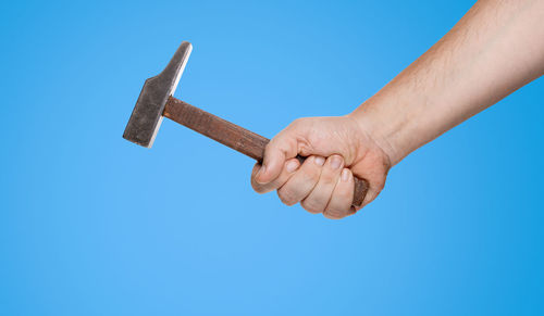 Low angle view of man hand against blue sky