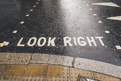 High angle view of text on wet road during rainy season