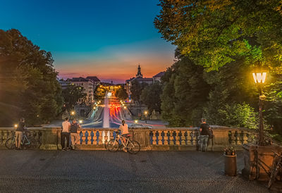 People sitting on illuminated street at night