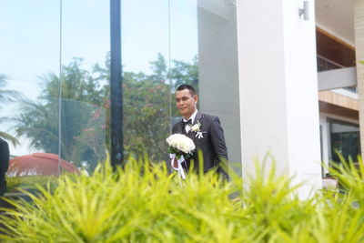 Full length of young couple on pink flowering plants