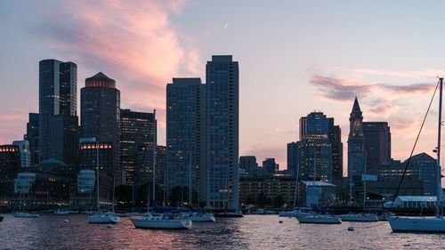 Modern buildings in city against sky during sunset