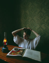 Rear view of woman sitting on table