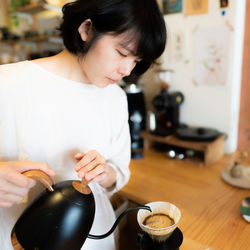 Woman making coffee in kitchen