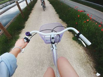 Low section of person riding bicycle on road