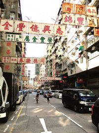 Cars on road against sky in city