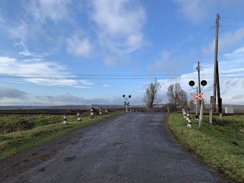Road passing through land against sky