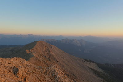 Scenic view of mountains against clear sky during sunset