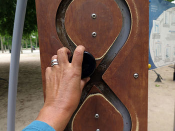 Cropped hand holding play equipment at playground