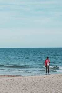 Rear view of friends standing on beach