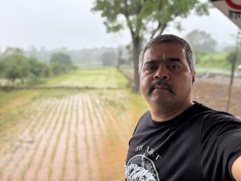 Portrait of young man standing on field