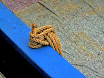 High angle view of rope tied on blue boat