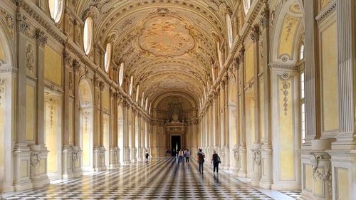 People walking in corridor of historic building