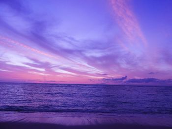 Scenic view of sea against dramatic sky during sunset