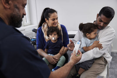 Male doctor examining family with children