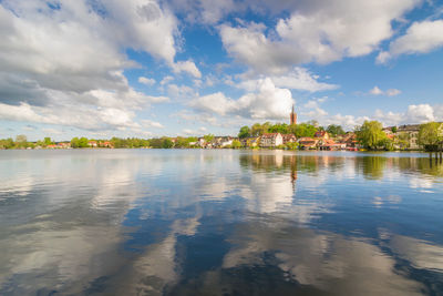 Scenic view of lake by building against sky