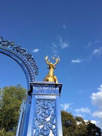 Low angle view of sculpture against blue sky