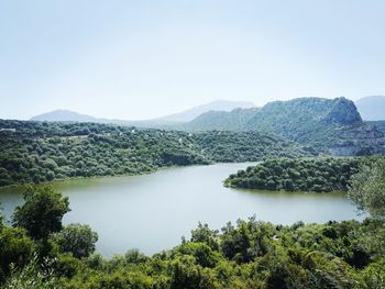 Scenic view of lake and mountains against clear sky