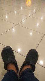 Low section of man standing on illuminated lamp