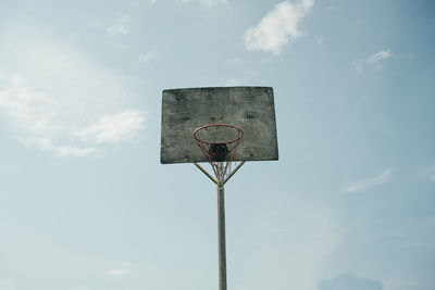 Old basketball backboard under blue sky