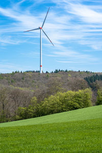 Windmill on field against sky