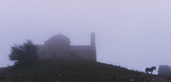 Building against sky during foggy weather