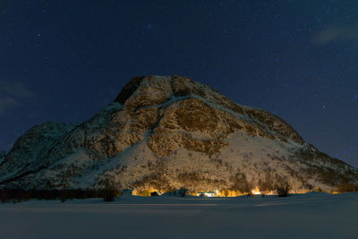 Scenic view of snowcapped mountains against sky at night