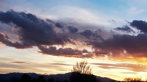 Low angle view of silhouette mountain against dramatic sky