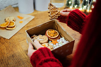 Christmas homemade sweet hampers in female hands. woman hsnds holding christmas sweet gift box