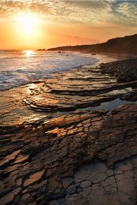 Scenic view of beach against sky during sunset