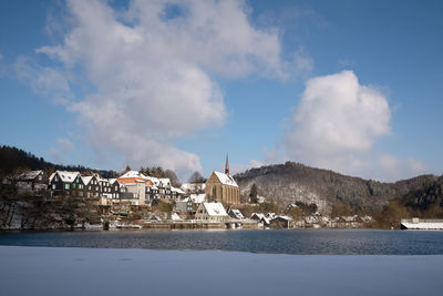 Panoramic view of lake by buildings against sky