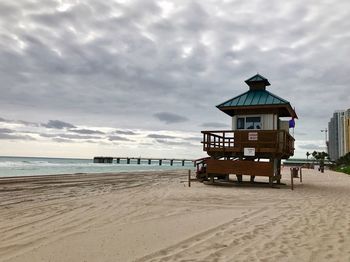 Lifeguard hut on beach against sky