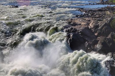 High angle view of waves breaking on rocks