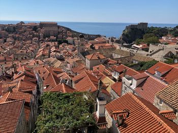 High angle view of townscape by sea against clear sky