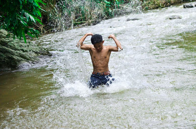 Rear view of shirtless man in water