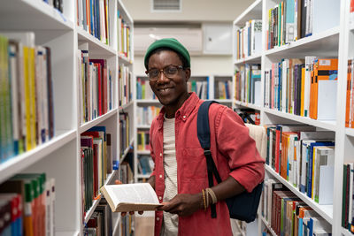 Portrait of young man standing in library