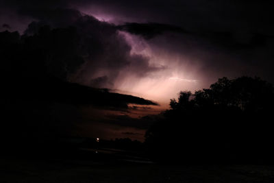 Silhouette of trees against cloudy sky