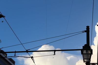 Low angle view of power lines against blue sky